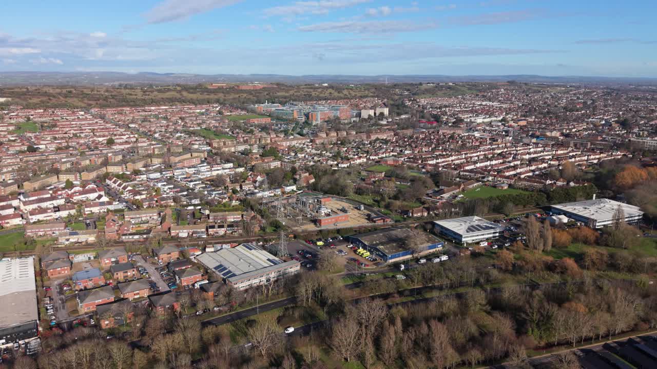 Penerbangan drone lambat tinggi di Portsmouth di atas area perkotaan yang didominasi perumahan menuju Rumah Sakit Queen Alexandra dengan pemandangan pedesaan di kejauhan pada hari yang cerah