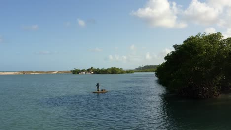 aerial drone shot of a local fishing boat on the water of the winding large tropical gramame river near the tropical beach capital city of joao pessoa in paraiba, brazil on a warm summer day