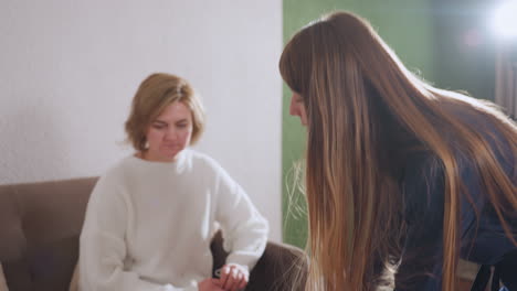 female therapist carrying tray walks to guest seated in cozy therapy room smiling warmly offers tray activity encouraging patient engagement during wellness session in soothing environment