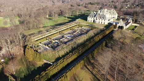 an aerial view over a large, upscale, luxury mansion with an eight reflection pool fountain, on long island, ny