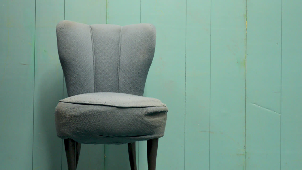 una vieja silla verde en una habitación verde