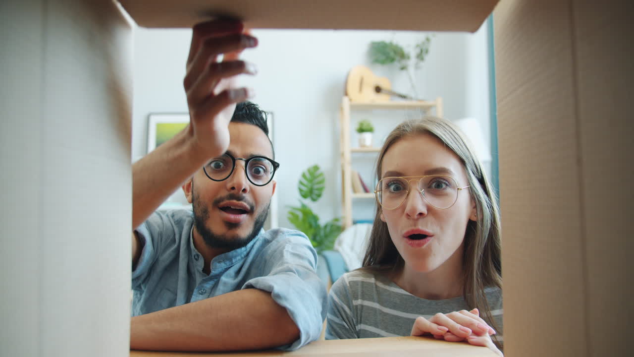 Excited Couple Opening a Cardboard Box