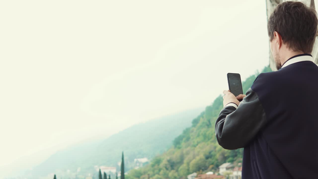 Man taking a picture of a scenic mountain view