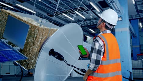 técnico de satélites que inspecciona el equipo en una instalación