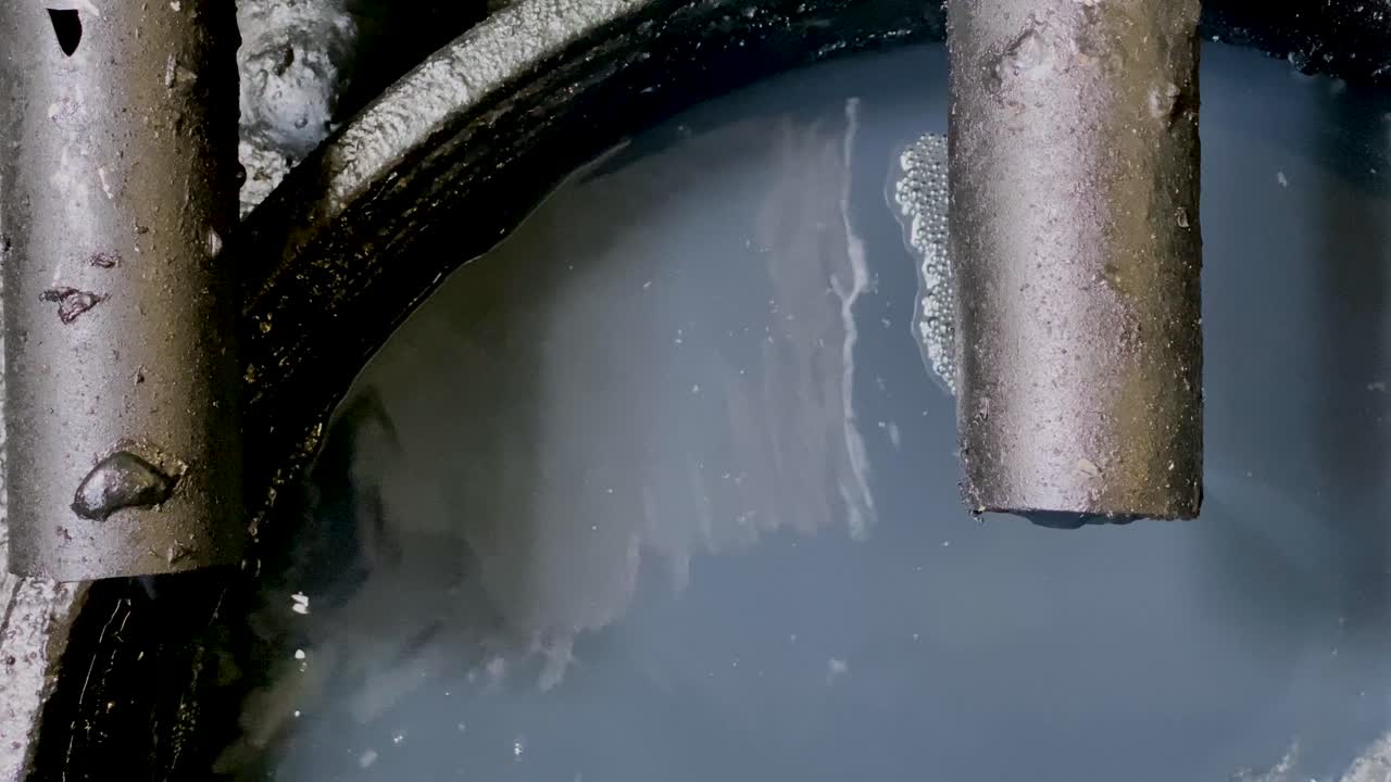 산업 공정에서 파이프에서 나오는 저장  ⁇ 크에 흘러내리는 검은 화학 폐수