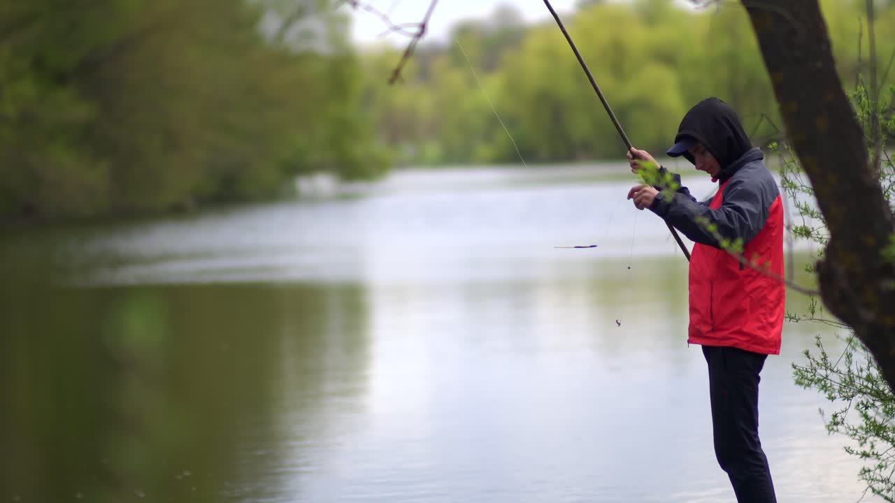 Remaja berjaket merah memancing dengan pancing 01