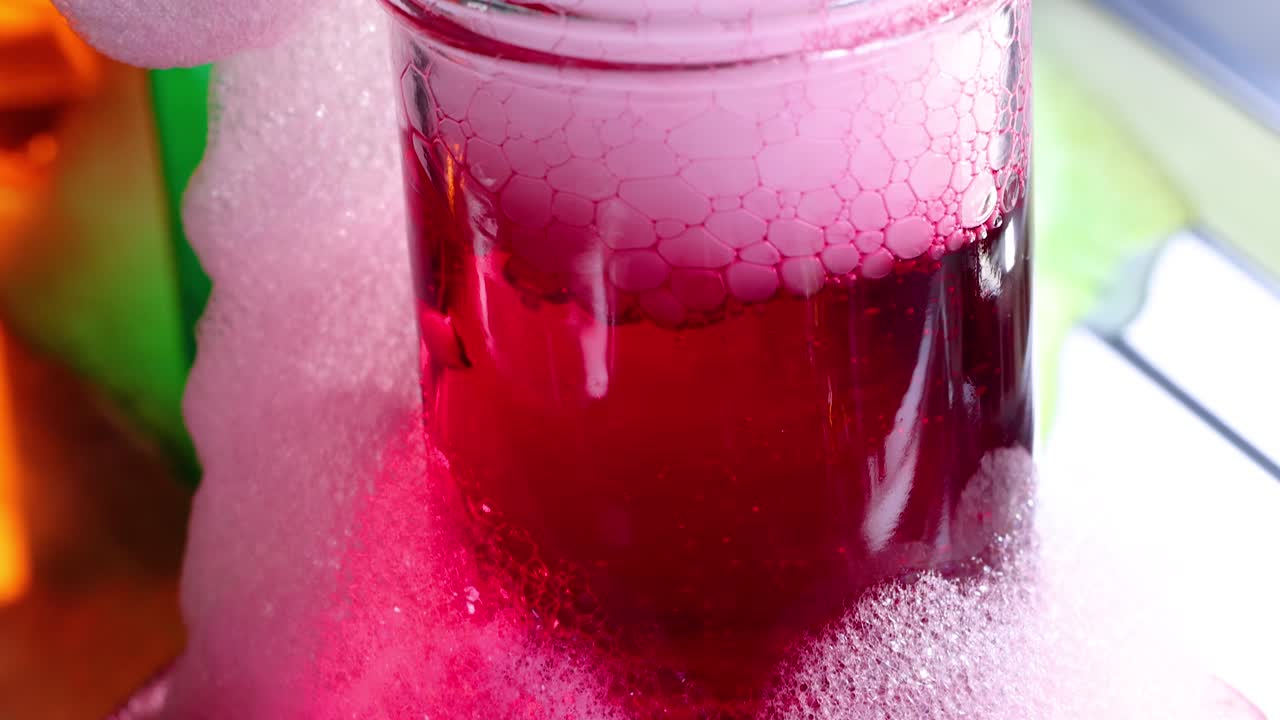 A vibrant science experiment with dry ice creating colorful bubbles in a glass container, showcasing chemical reactions and vivid visuals