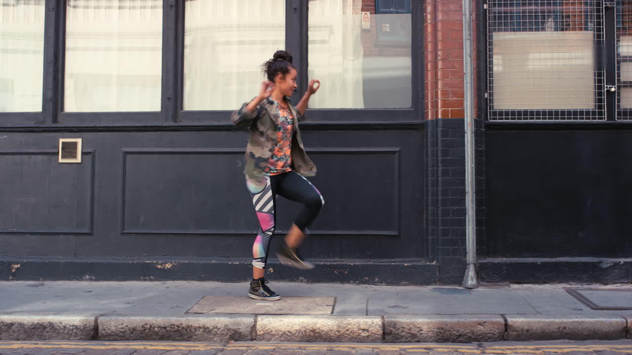contemporánea funky mujer de raza mixta bailarina de calle bailando estilo libre en la ciudad
