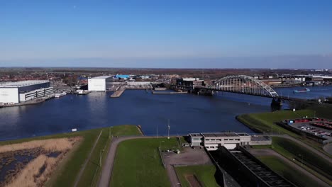 Aerial-View-Of-Arch-Bridge-Spanning-At-Noord-River-With-Blue-Sky-In-the-Background