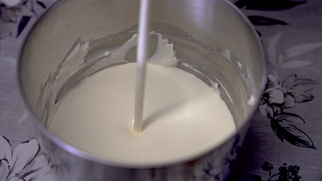 fresh cream being poured into mixing tin