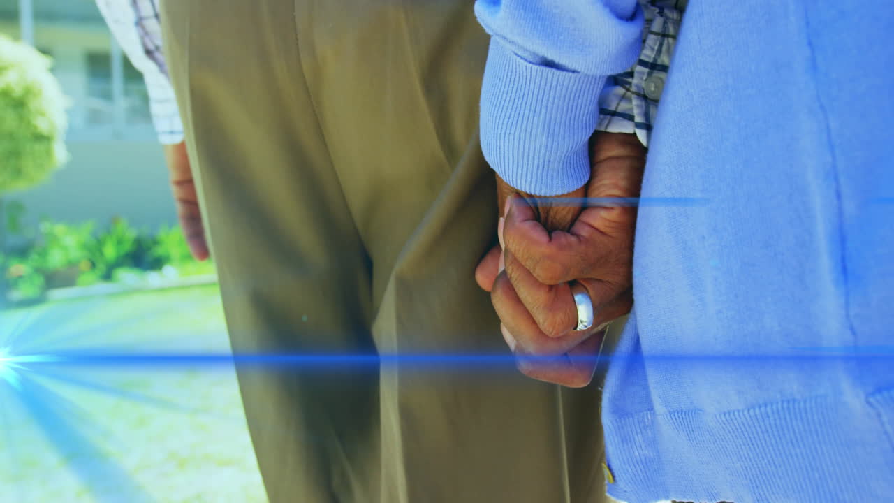 animación de la luz que se mueve sobre la sección media de la pareja de ancianos caminando tomados de la mano
