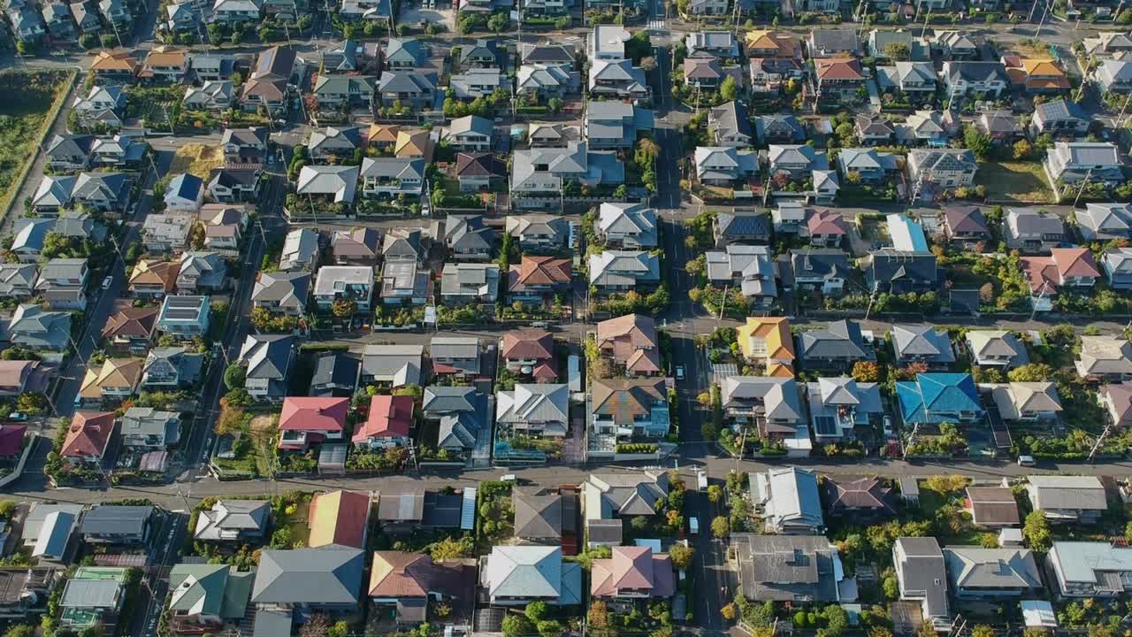 Bidikan drone dari atas ke bawah bergerak maju di atas rumah-rumah hunian warna-warni di Kyoto