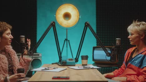 two female co-hosts having discussion in podcast recording studio