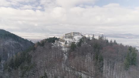 Aerial-view-of-Rasnov-Citadel-in-Romania,-during-winter-time