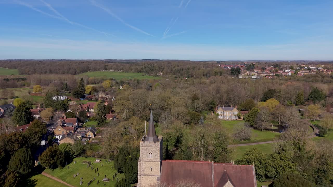 St Mary's Church, Hertingfordbury drone flight approaching the medieval parish church with stone tower and pitched nave roof, set among village homes and Hertfordshire countryside