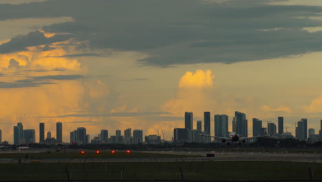 airplane landing at airport with city skyline at sunset