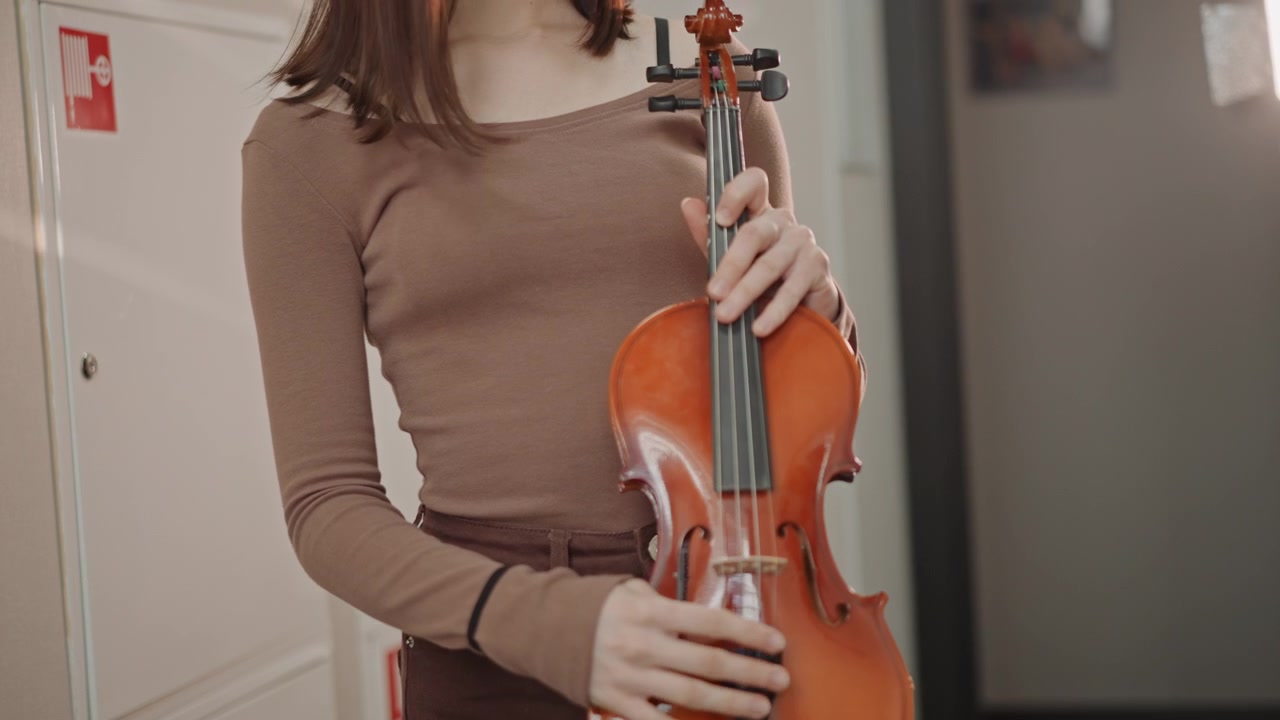 Confident student showcases instrument skill. Young performer ready to play violin confidently. An inspired young performer prepares confidently to showcase their musical talent with violin
