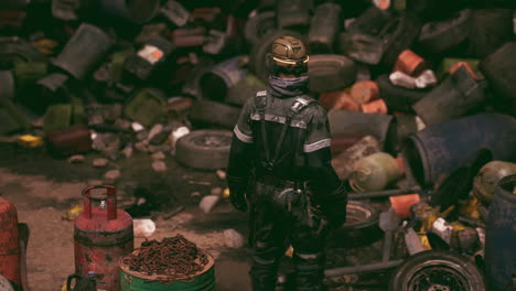 worker surveying an industrial site filled with discarded materials and waste