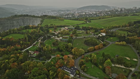 Usti-nad-Labem-Czechia-Aerial-v5-panoramic-panning-view,-drone-flyover-hillside-zoo-capturing-industrial-area-by-the-bank-of-Elbe-river-and-massive-quarry-site---Shot-with-Mavic-3-Cine---November-2022