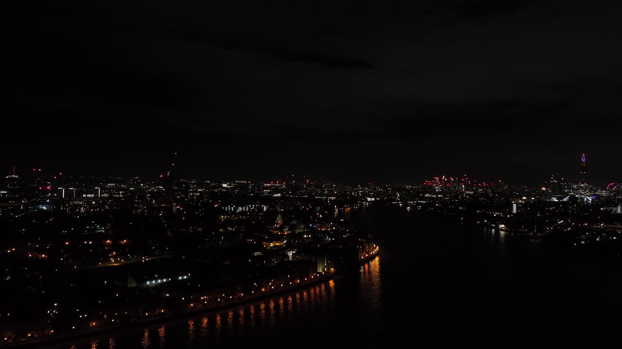 Aerial view rising from the Isle of Dogs, at Thames river and London Skyline, night