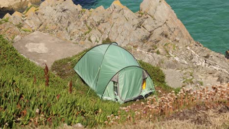 hand-held shot of a tent pitched on the cliffside of the headlands in newquay