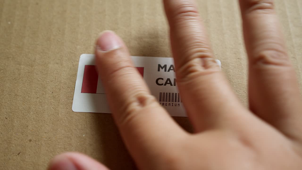 Hands applying MADE IN CANADA flag label on a shipping box with product premium quality barcode