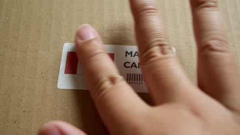 hands applying made in canada flag label on a shipping box with product premium quality barcode