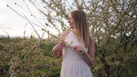 hermosa mujer rubia en un huerto en flor en la primavera retrato de una dama encantadora en la naturaleza