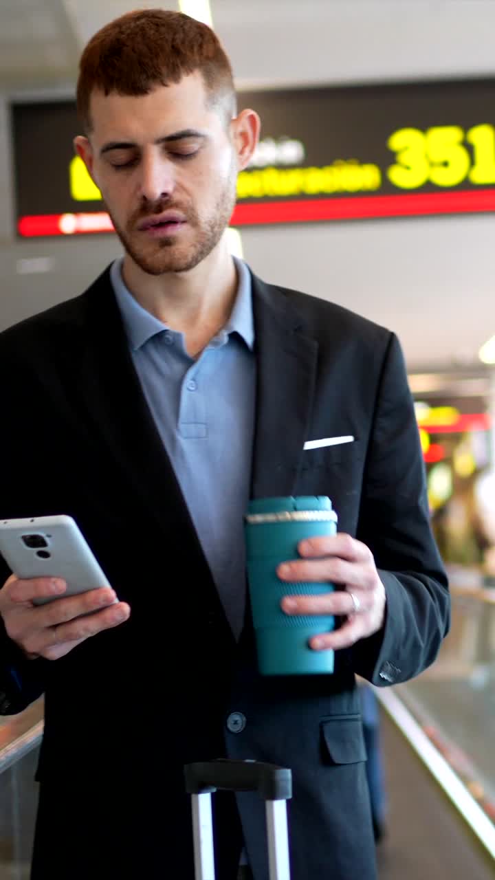 Man at Airport with Phone and Coffee