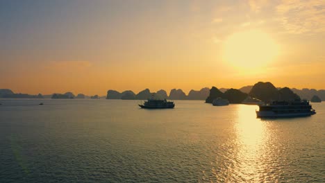 aerial landscape of many cruise ships anchored at halong bay backlit with rising bright sun, vietnam