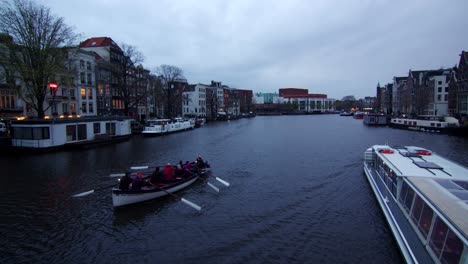 Amsterdam,-Holland,-Rowers-and-boat-in-water-canal,-Wide-static-shot,-blue-hour