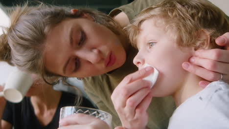 lesbian mother taking care of little son on family breakfast