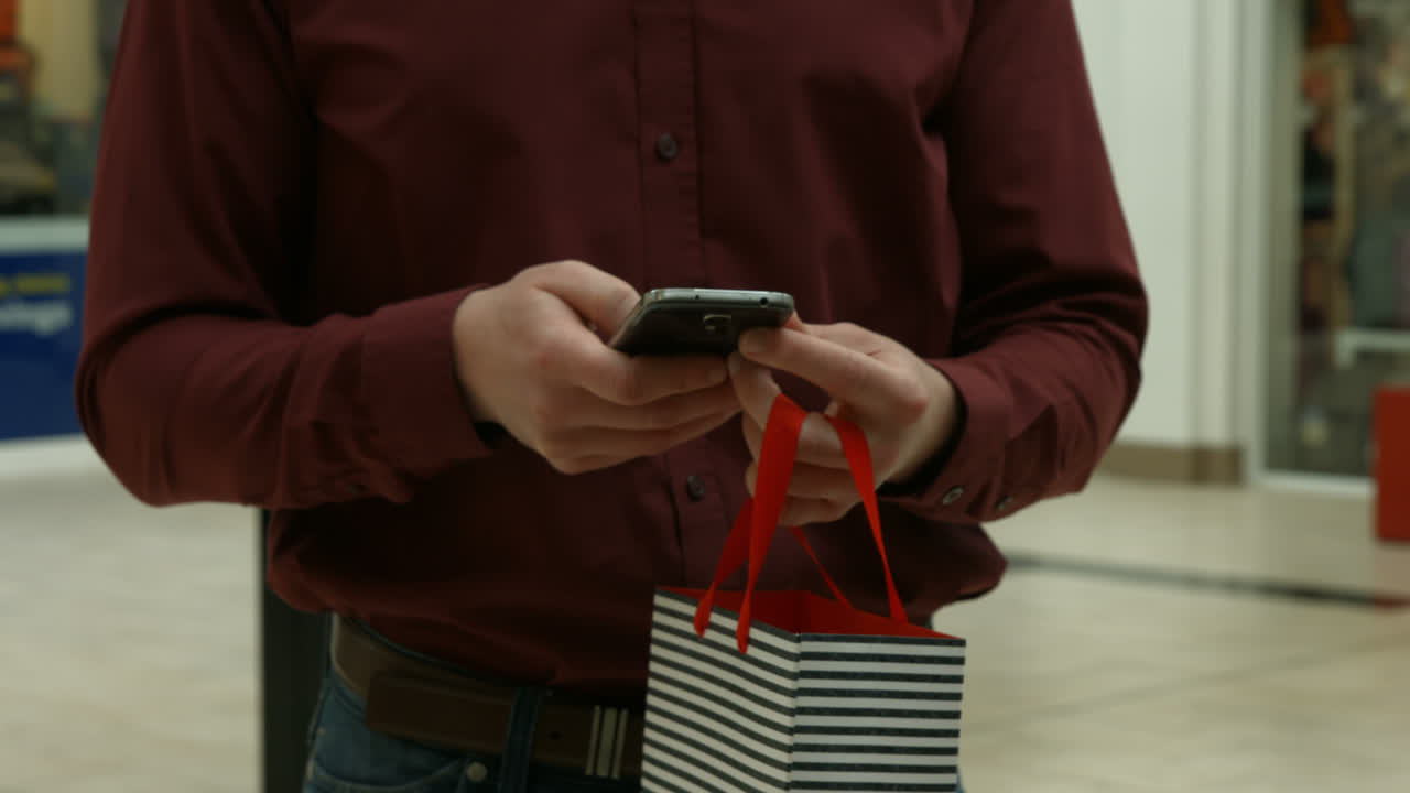 sección media del hombre usando su teléfono inteligente