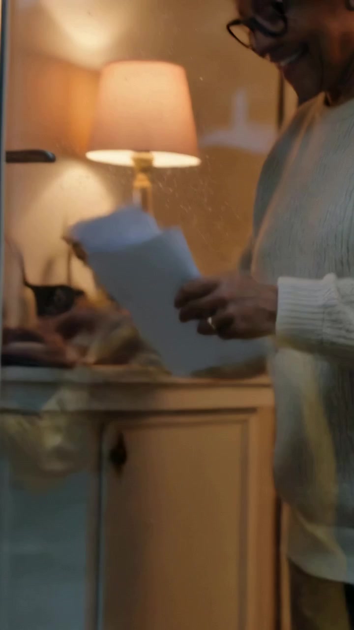 Vertical video: Stepping child in yellow raincoat handing folded paper at front door