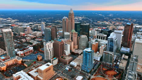 flying closer to the high-rise architecture in the uptown of charlotte, nc, us. vast scenery with lots of greenery at backdrop