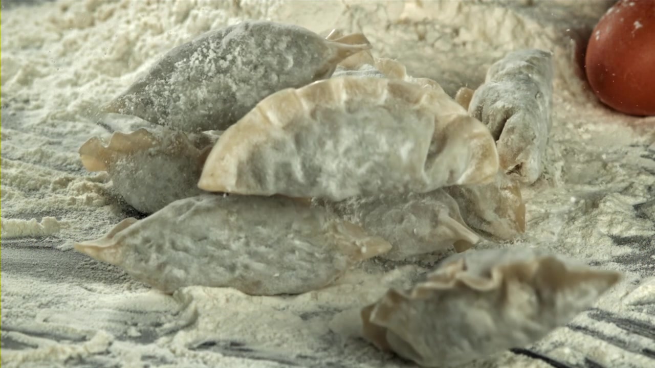 Ravioli appena fatti che cadono sulla farina al rallentatore