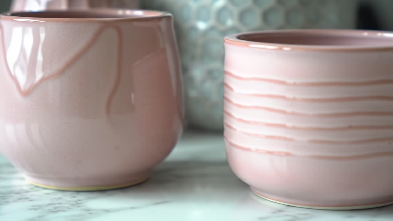 Elegant Pink Pottery: A Close-Up View of Beautifully Crafted Pink Ceramic Containers on a Marble Surface, Showcasing Their Unique Designs and Textures
