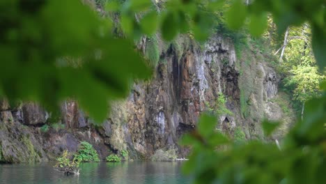 hermosa vista de un acantilado y un lago visto a través de las ramas de los árboles