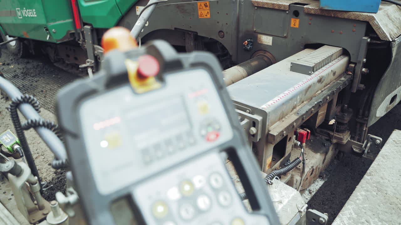 Road construction works during making new asphalt road. Paving machine laying fresh asphalt during road construction. Close-up