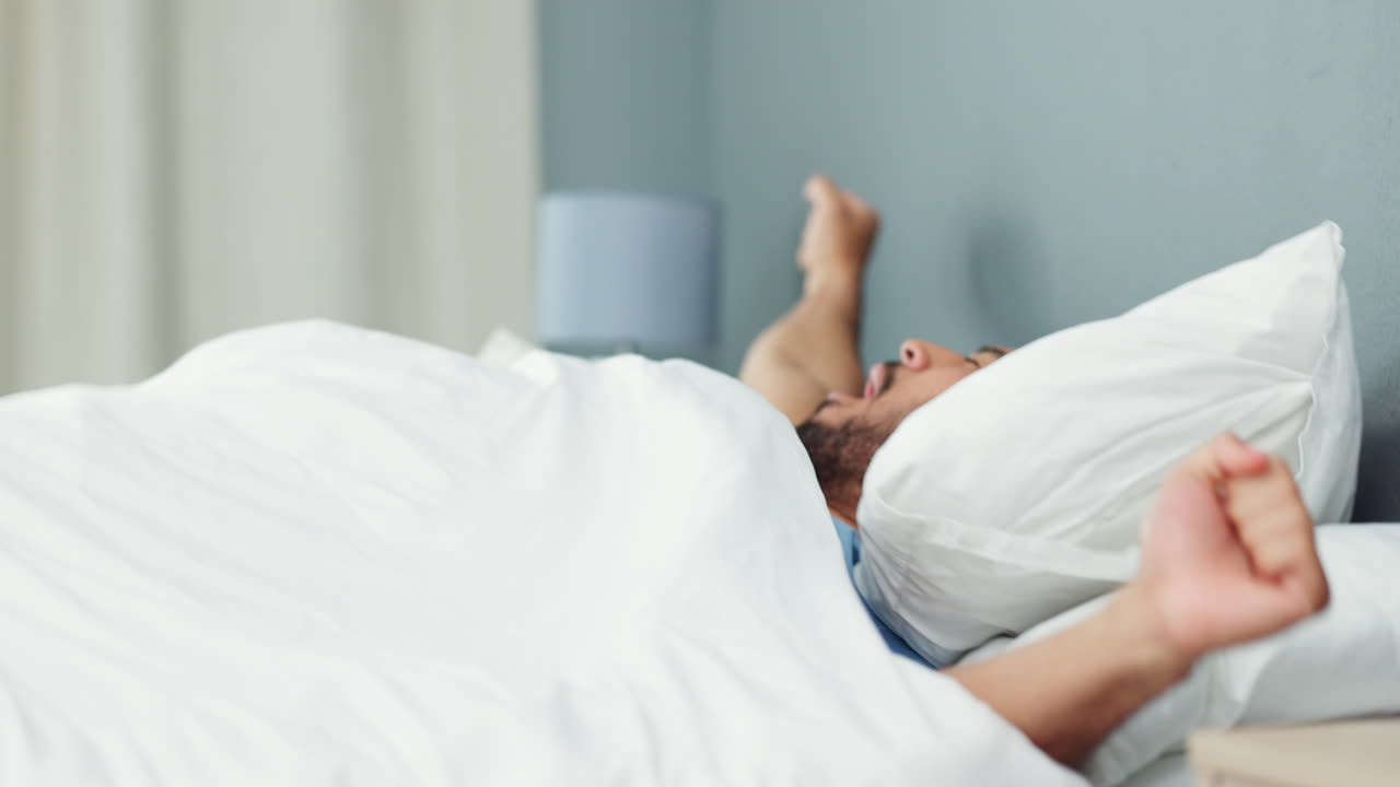 잠에서 깨어나는 알람 시계와 함께 피곤한 남자