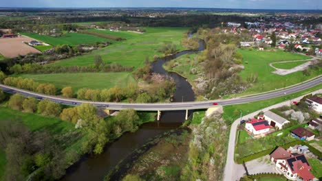 Toma-Aérea-De-Drones,-Ciudad-De-Łęczna,-Polonia,-Puente-Viejo,-Río,-Naturaleza,-Día-Soleado