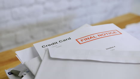 a stack of bills and letters with final notice for credit card debts