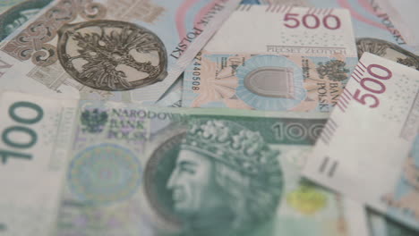 panning: several 500 pln banknotes lie next to each other, polish money on rich moment