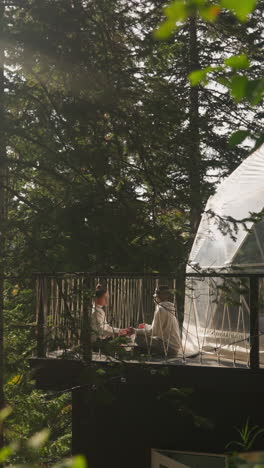 un refugio exclusivo para la práctica del yoga. el marido y la esposa pasan tiempo juntos meditando cerca de viviendas semiesféricas. entorno natural inmersivo