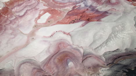 Aerial-view-tilting-over-rock-formations-in-sunny-Bentonite-Hills,-Utah,-USA