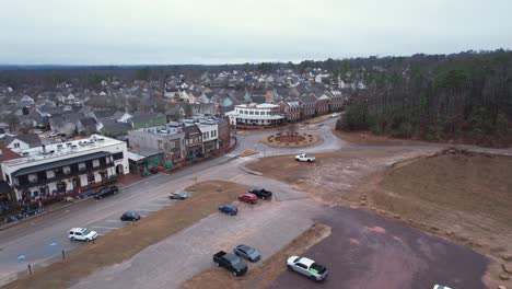 aerial pan of small town shops and roundabout in front of suburbs at moss rock preserve in hoover, alabama