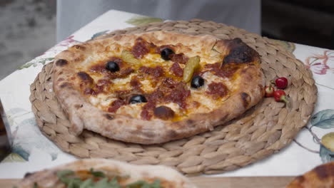 Putting-topping-onto-freshly-baked-pizza