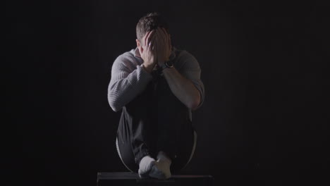 mental illness concept background, depressed man having mental breakdown, swings back and forth in dark room