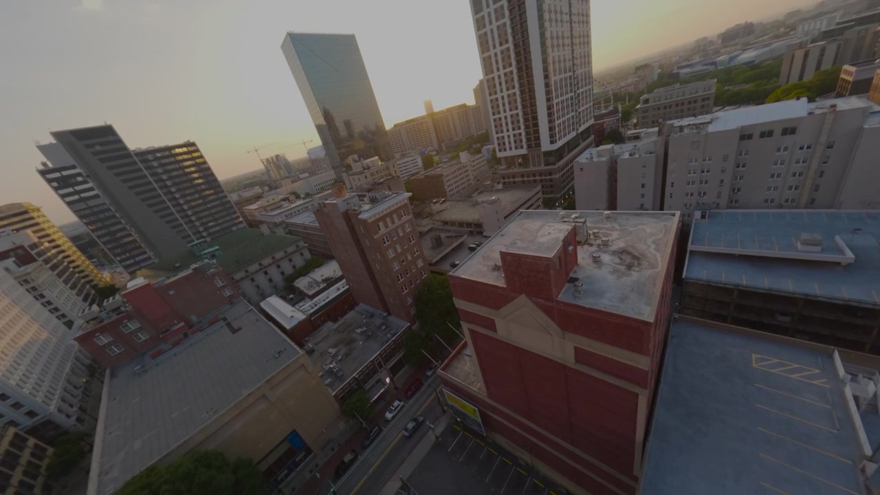 Vuelo acrobático de dron FPV descendiendo a lo largo de un rascacielos hacia las calles del centro de Atlanta