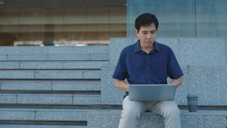 Man Working on Laptop on Outdoor Stairs
